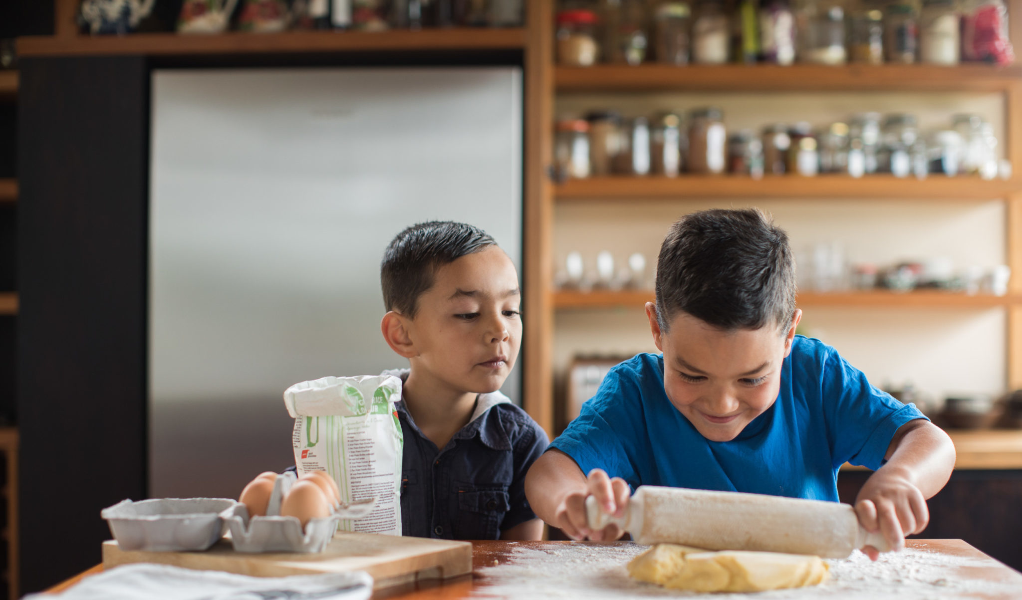 Two boys baking in the kitchen.